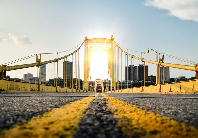 Looking up at a yellow Pittsburgh bridge