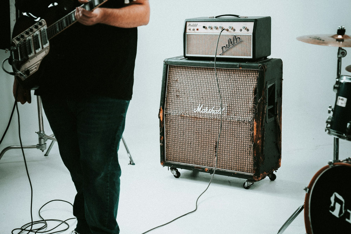 A guitar amplifier and drum kit on a small stage