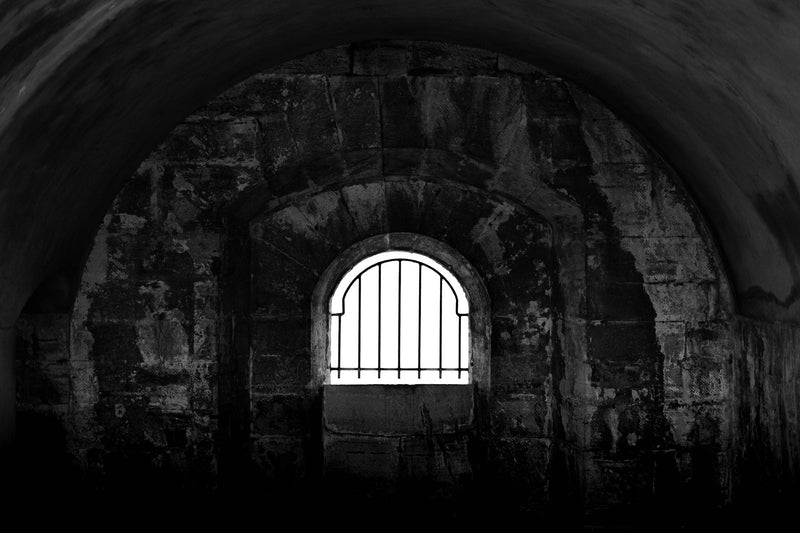 A barred window in an old stone jail